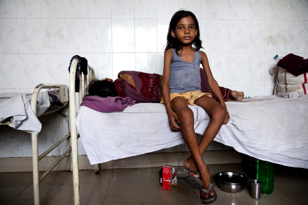 Young girl sitting on a hospital bed