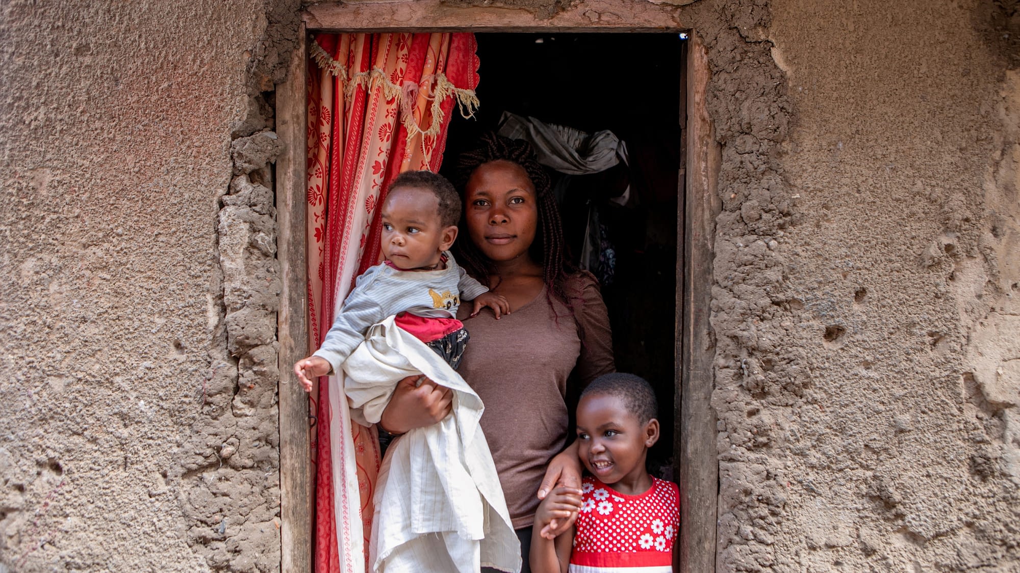 Mother with her two children in front of house