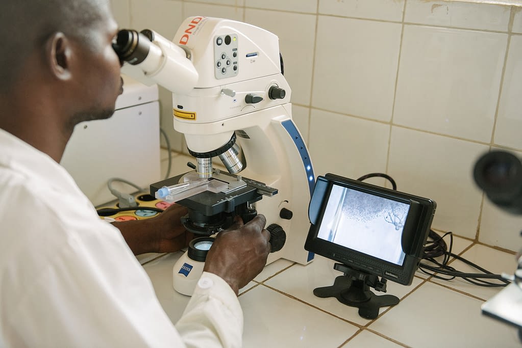 Clinician looking into a microscope