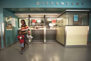 Mother and son collecting HIV medicines at hospital dispensary in Durban