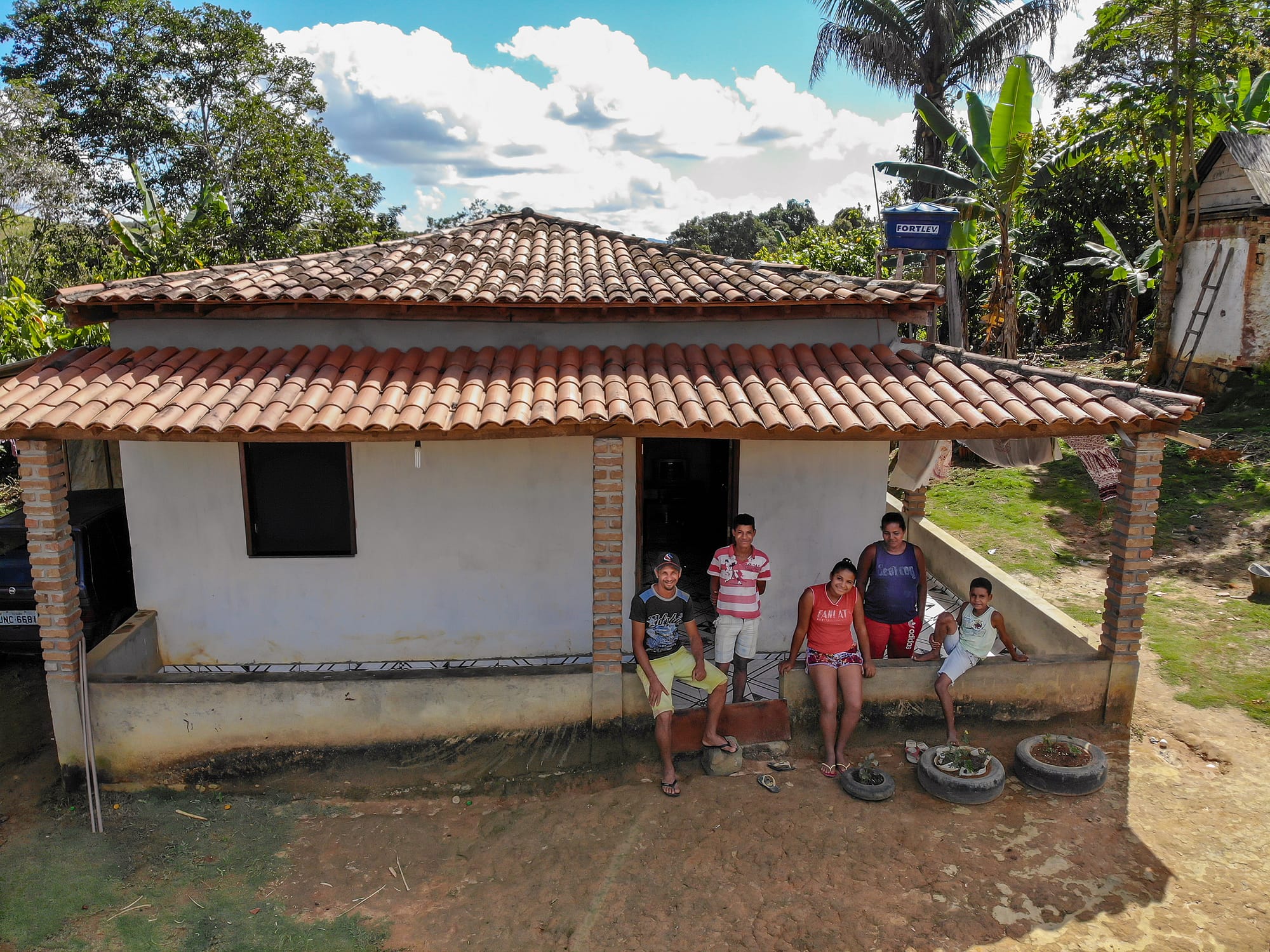 Family in front of their house in rural setting