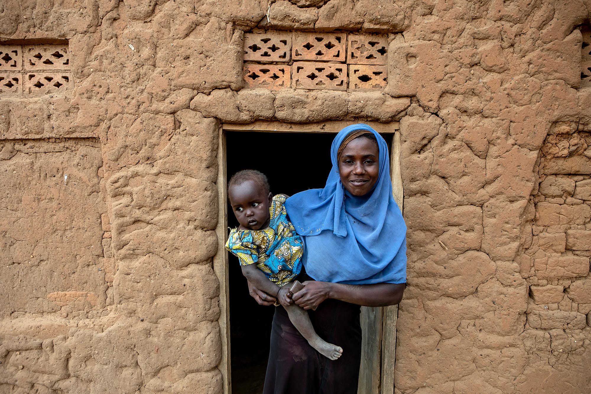 Mother with her child in front of a house