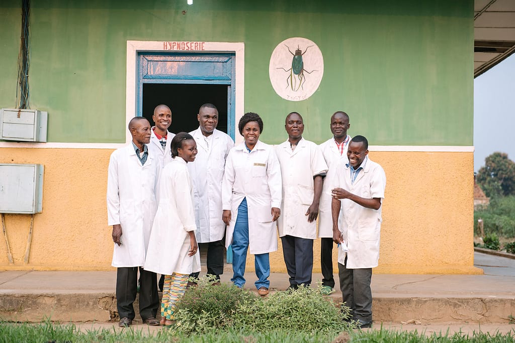 Healthcare workers and doctors outside of a hospital treating sleeping sickness patients