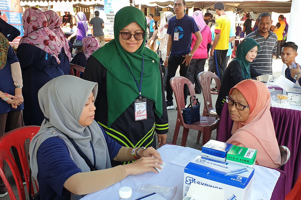 One of the clinical volunteers from Hospital Tengku Ampuan Afzan (HTAA) preparing to screen a woman for hepatitis C