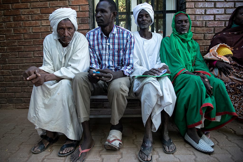 Mycetoma patients sitting in front of a hospital