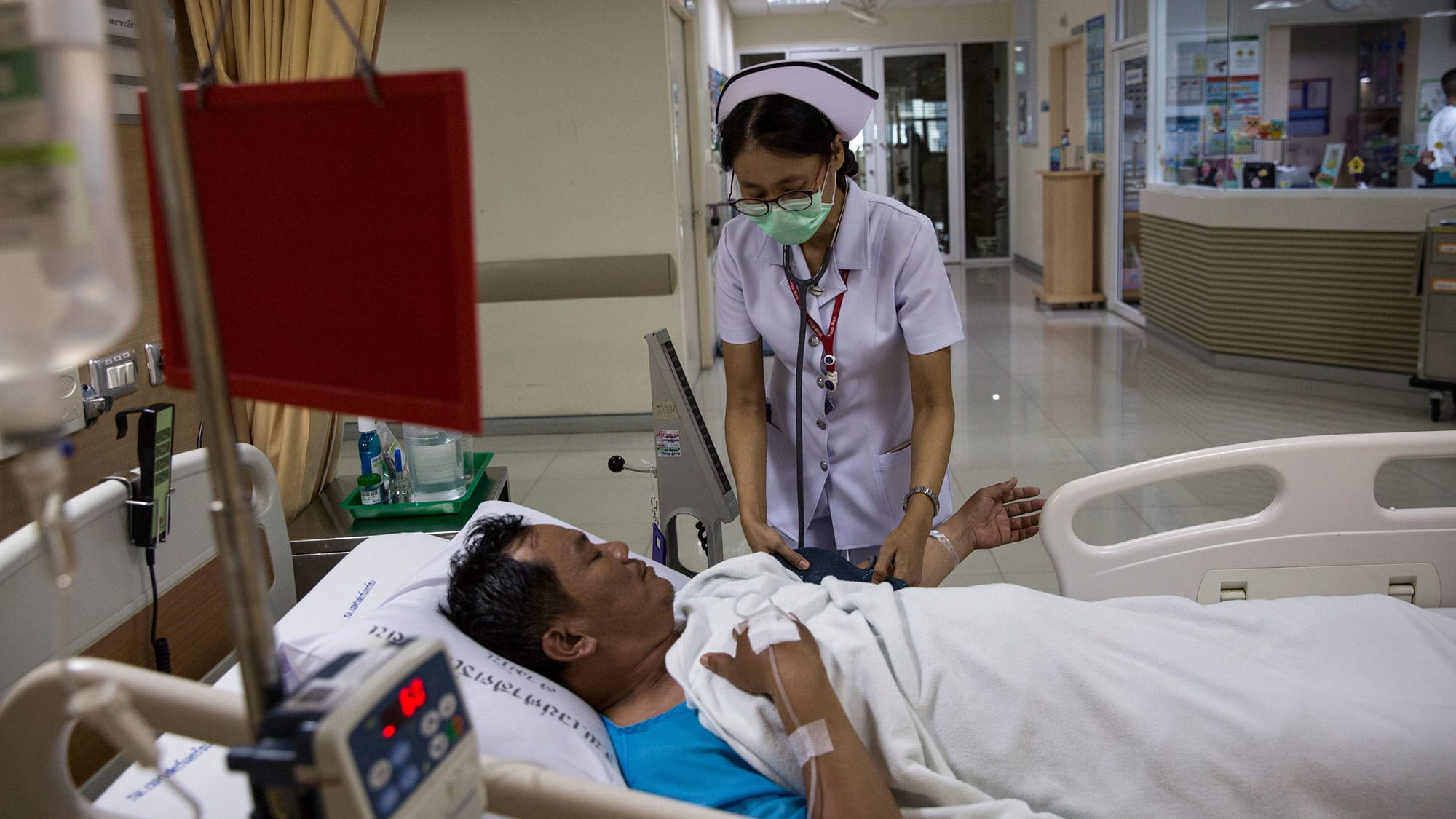 Healthcare worker tending patient in hospital setting