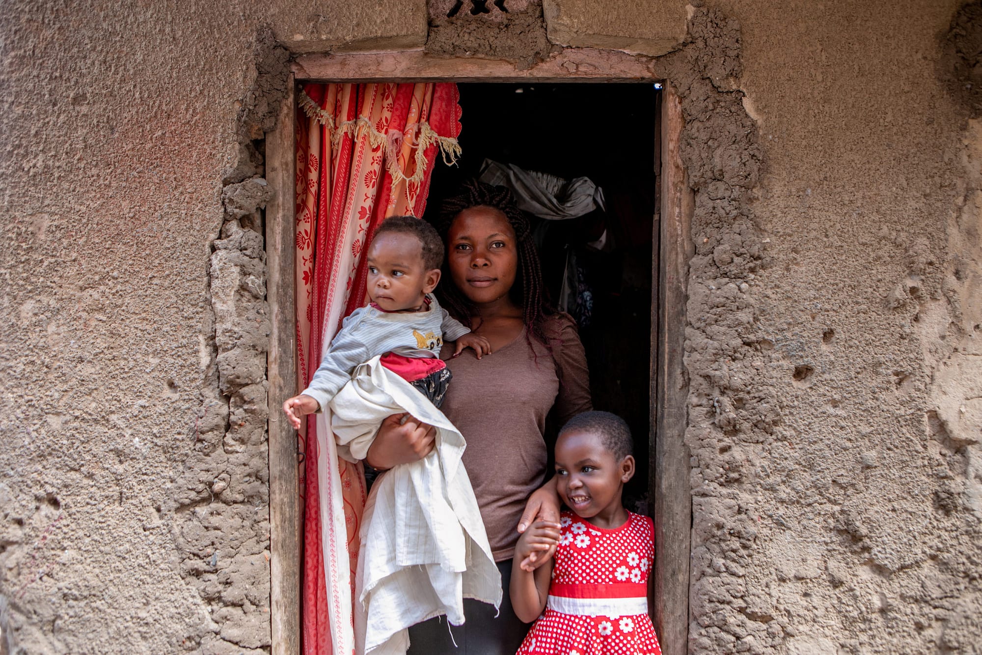 Mother with her two children in front of a house
