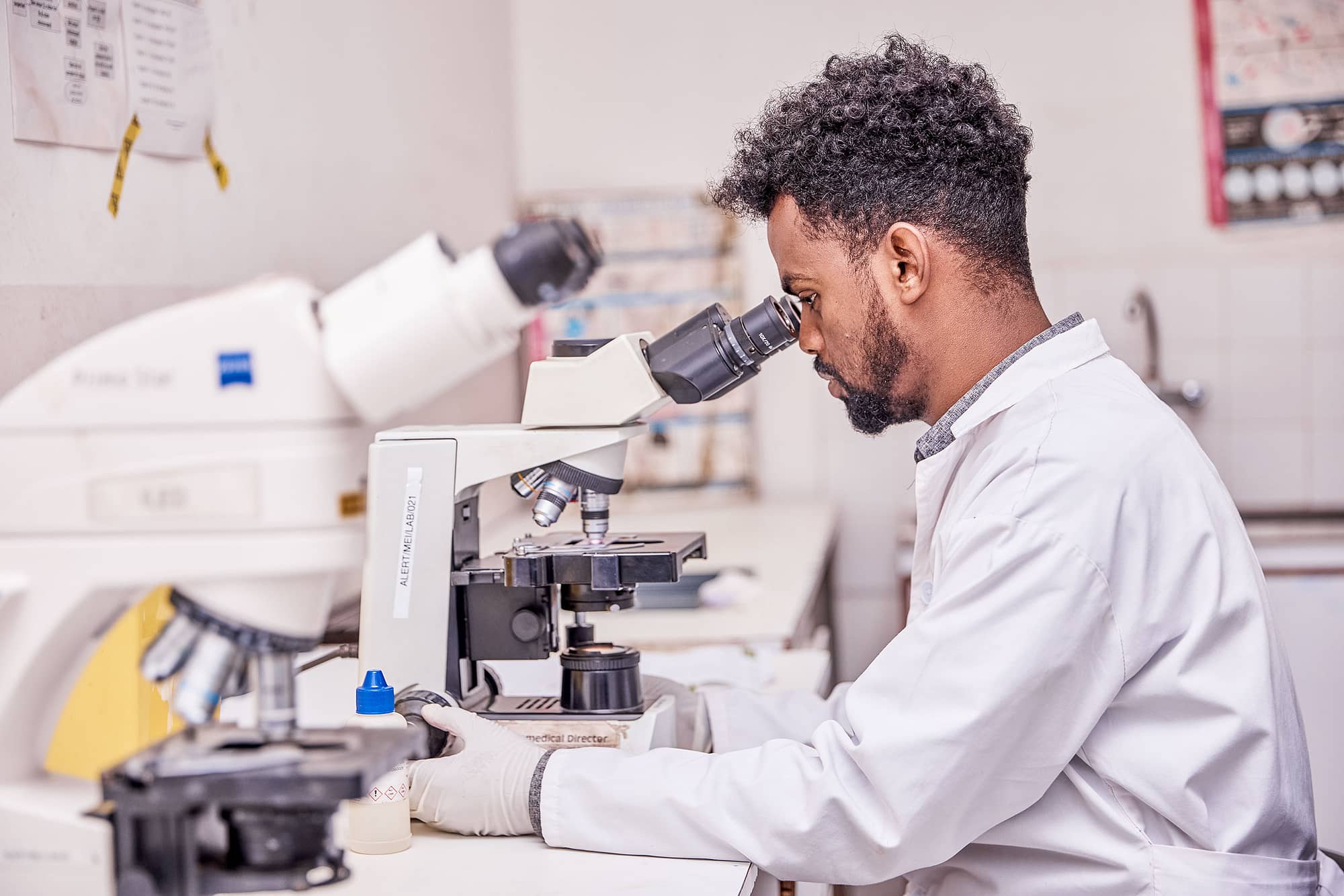 Health worker looking into a microscope