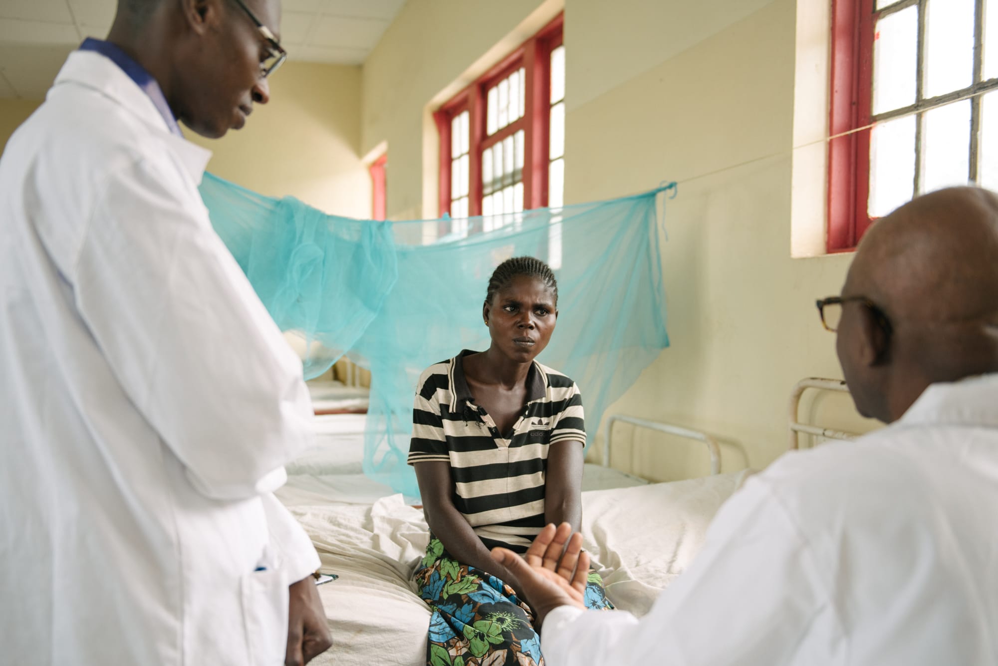 Doctors talking with patient in hospital
