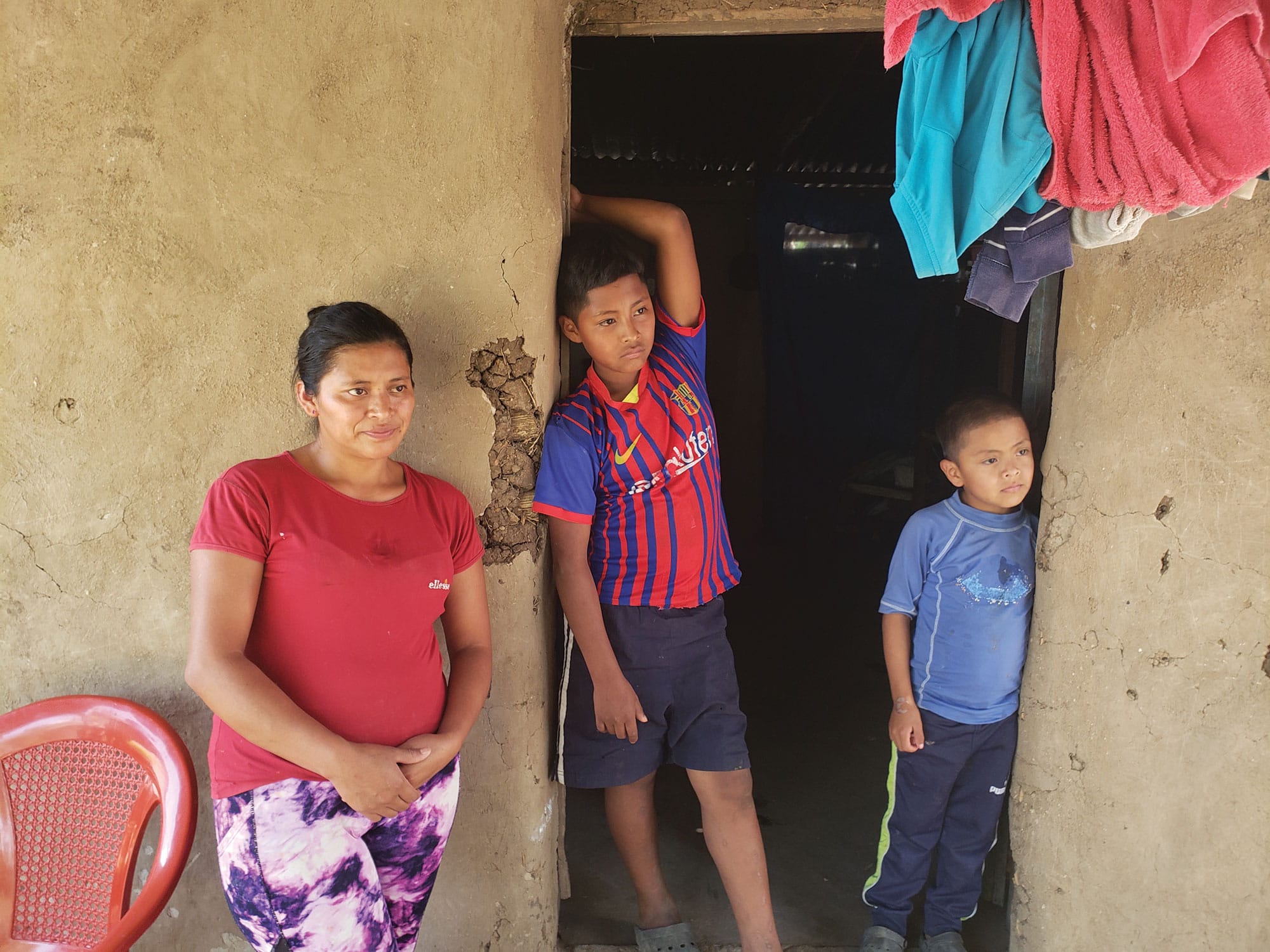 Mother and children stand by a doorway