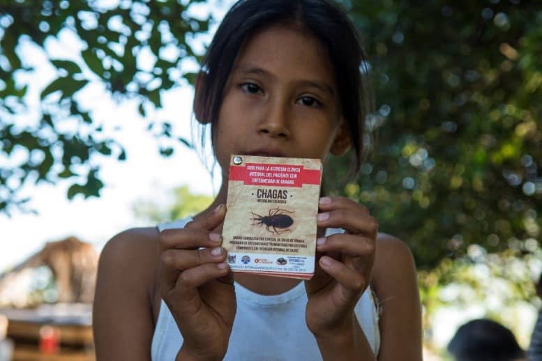 Young girl holding a flyer on Chagas disease